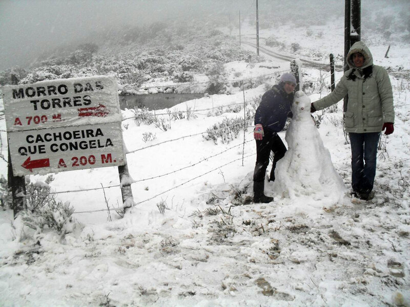 Placa do Morro das Torres e visitantes na neve, com indicação da Cachoeira que Congela