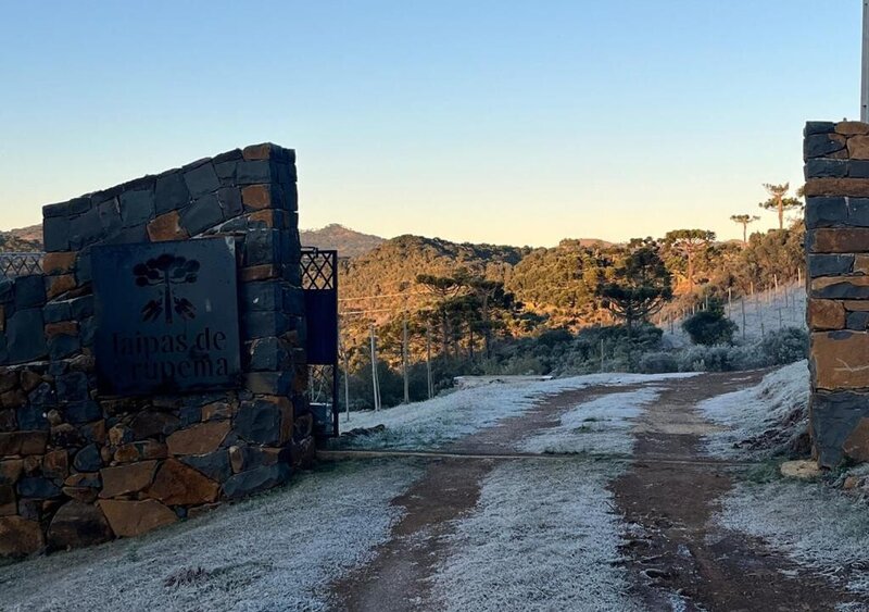 Entrada de propriedade com muro de taipas de pedra, com a inscrição Taipas de Urupema